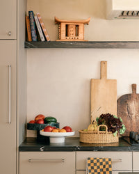 Kitchen counter with fruits, vegetables, and a cutting board.