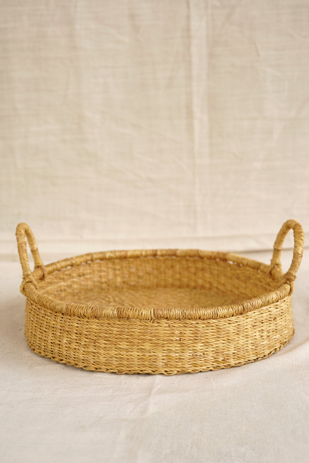 Woven basket with handles on a beige background