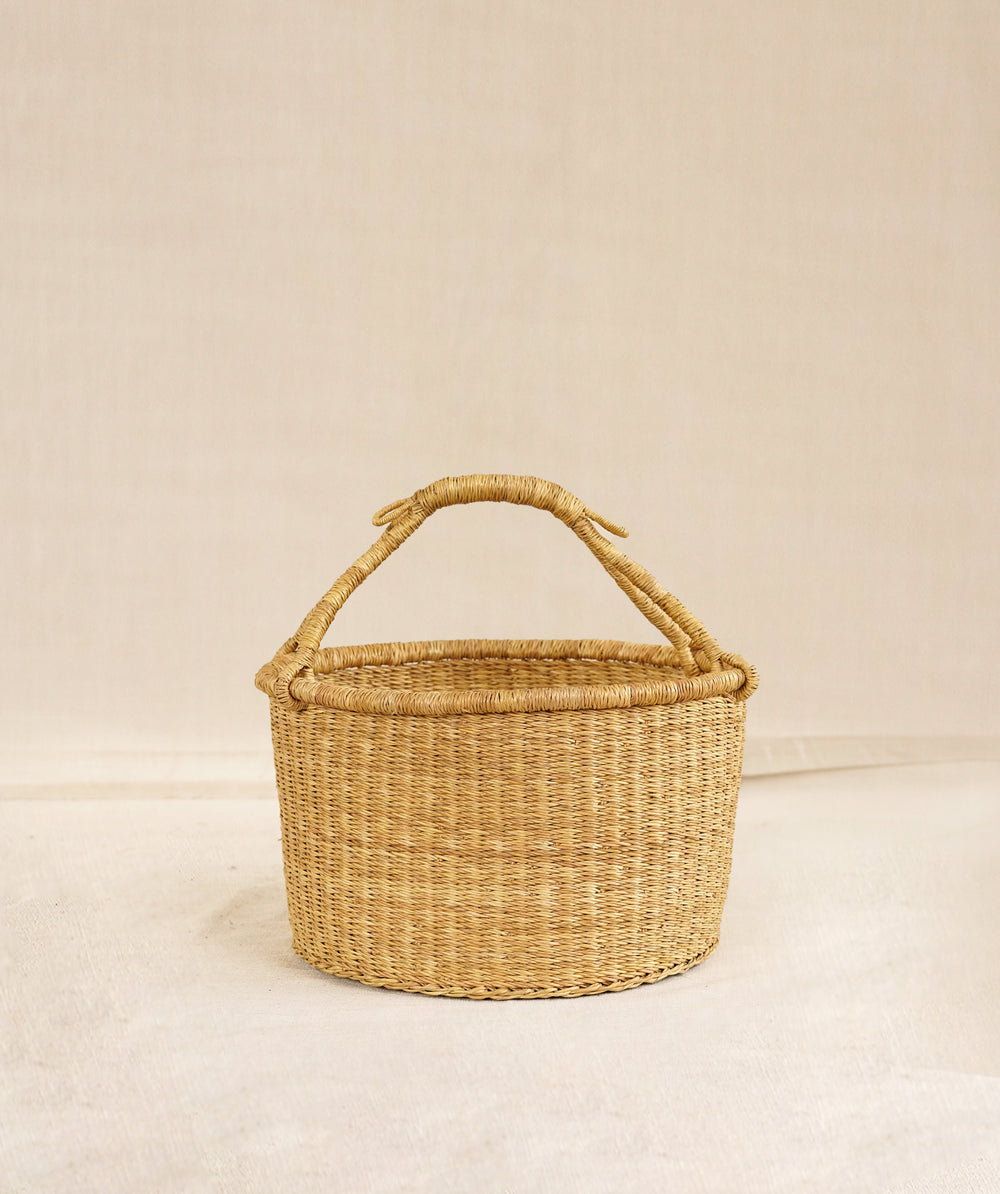 Elephant Grass basket with handle on a beige background