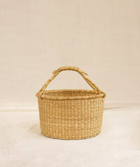 Elephant Grass basket with handle on a beige background