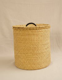 Woven laundry basket with a lid on a beige background