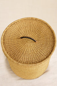 Woven basket with a lid on a beige background