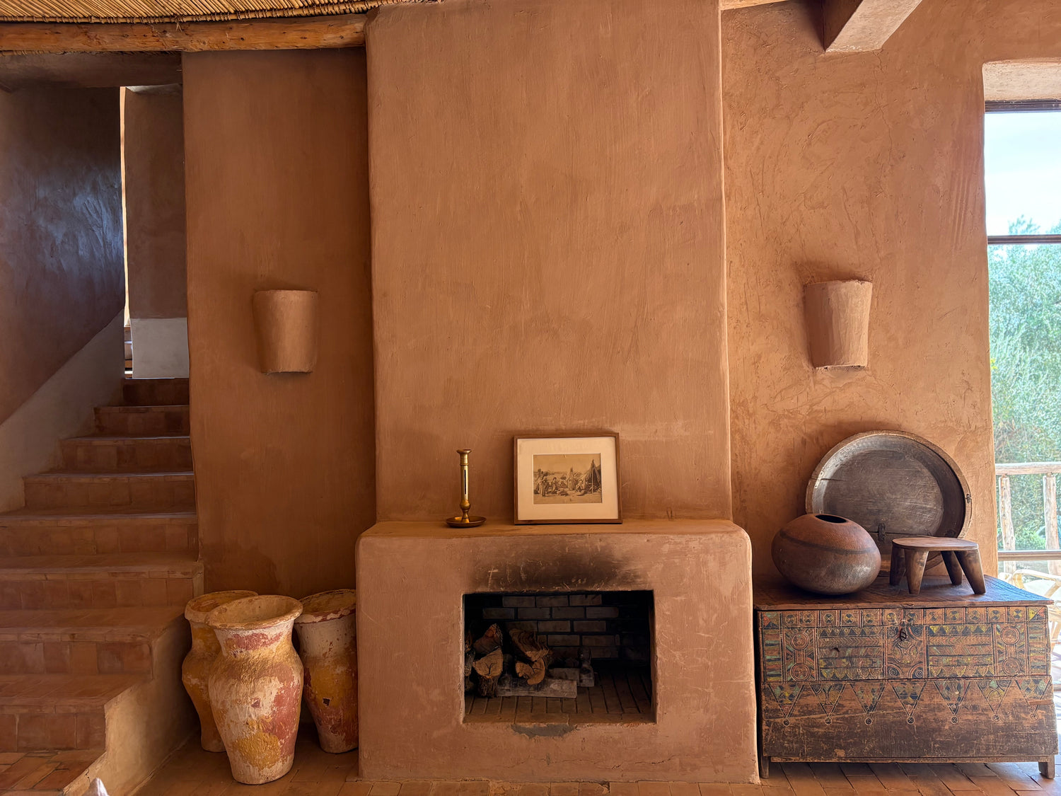 Terra cotta fireplace with decorative items in a rustic setting