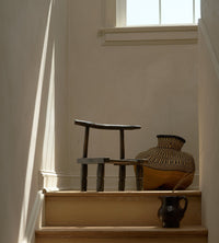Wooden chair and vase on a staircase with soft lighting