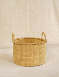 Woven basket with handles on a beige background