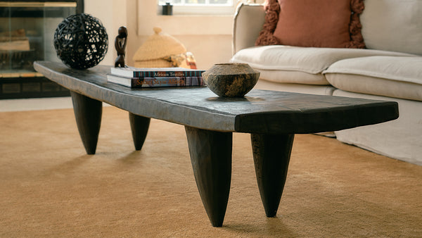 Senufo bench used as a coffee  table with unique design in a living room setting