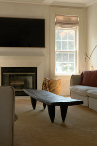 Living room with a fireplace, bench, and window