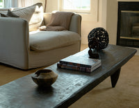 Living room with a beige sofa, coffee table, and decorative items.