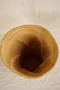 Top view of a woven basket on a beige fabric background